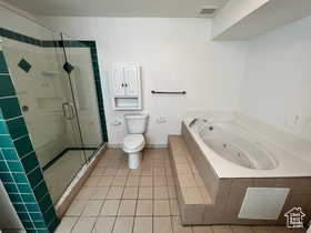 Full bathroom featuring a shower stall, light tile patterned flooring, and a jetted tub