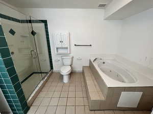 Full bathroom featuring a stall shower, light tile patterned flooring, and a jetted tub