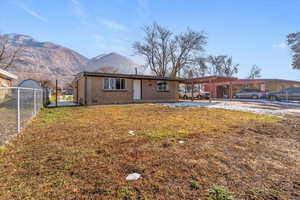Back of property featuring brick siding, a mountain view, and an attached carport