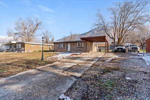 View of front of house with driveway, brick siding, and a mountain view