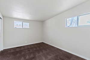 Unfurnished bedroom with dark colored carpet and a closet