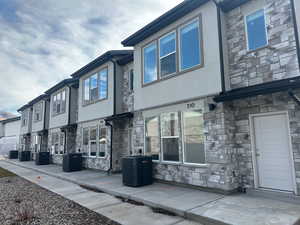View of side of property featuring stone siding and stucco siding