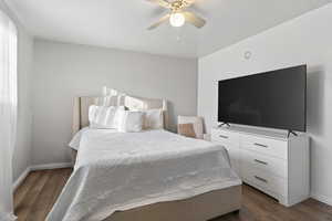 Bedroom with dark wood-style flooring and a ceiling fan