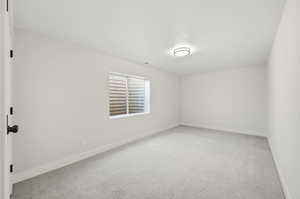 Spare room with light carpet and baseboards