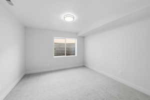Unfurnished room featuring light colored carpet and baseboards