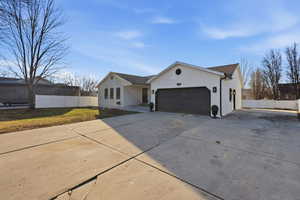 Single story home with driveway, stucco siding, and a garage