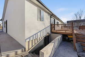 View of property exterior with stucco siding and a deck