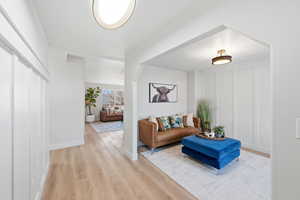 Living room featuring light wood-style floors and a decorative wall