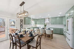 Dining area featuring french doors, light wood-style flooring, lofted ceiling, and recessed lighting