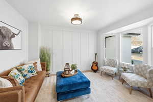 Living area featuring a decorative wall and wood finished floors
