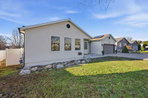 View of front of property with roof mounted solar panels, concrete driveway, stucco siding, and a garage