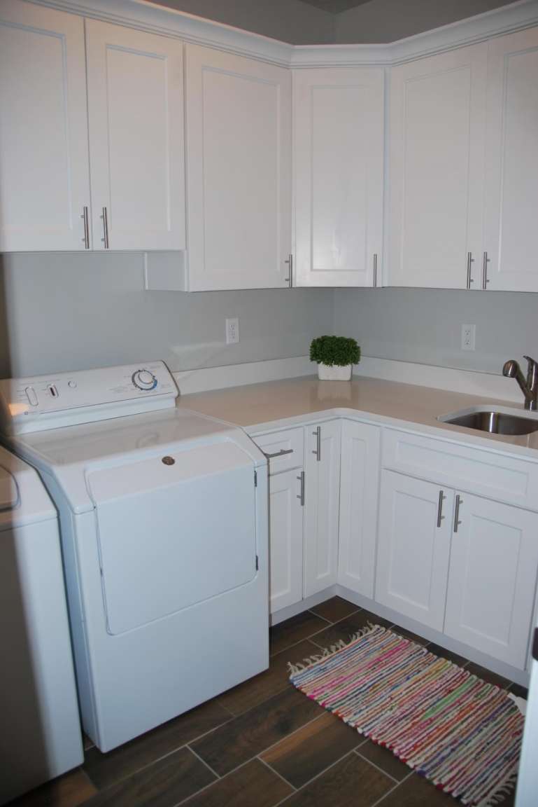 Laundry area featuring cabinet space, wood finish floors, and washing machine and dryer