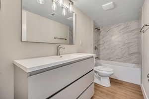 Bathroom featuring vanity, tub / shower combination, and light wood-style flooring