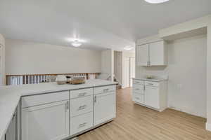 Kitchen with white cabinetry and light wood finished floors