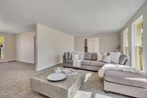 Carpeted living area featuring baseboards