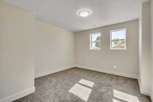 Unfurnished room featuring baseboards and light carpet