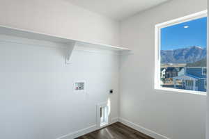 Washroom featuring washer hookup, electric dryer hookup, dark wood finished floors, and healthy amount of natural light