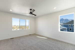 Unfurnished room featuring light colored carpet, a ceiling fan, and recessed lighting
