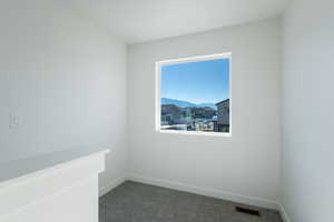 Spare room featuring dark colored carpet