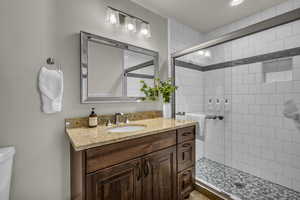 Full bath featuring vanity and a tile shower