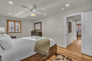 Bedroom with light wood finished floors, multiple windows, ceiling fan, recessed lighting, and a textured ceiling