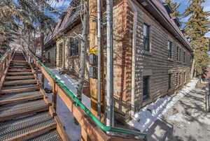 View of side of home with stone siding and stairs