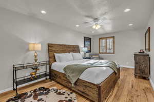 Bedroom with recessed lighting, ceiling fan, light wood-type flooring, and a textured ceiling