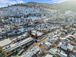 Snowy aerial view featuring a mountain view and a residential view