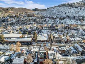 Snowy aerial view featuring a mountain view and a residential view