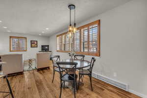 Dining space with light wood-type flooring, a textured ceiling, and recessed lighting