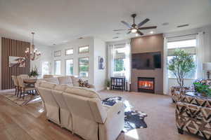 Living room with a custom tiled gas fireplace, a ceiling fan, and lots of natural light coming in