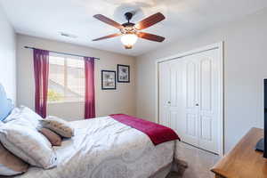 Bedroom featuring carpet flooring, a closet, and a ceiling fan