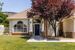 Entrance to property with stucco siding and brick siding