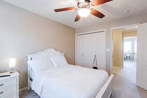 Bedroom with a ceiling fan, a closet, and carpet flooring
