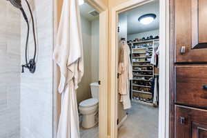 Bathroom with a spacious closet and a stall shower