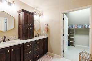 Bathroom with double vanity and a spacious closet