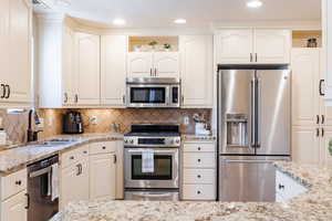 Kitchen featuring appliances with stainless steel finishes, light stone counters, open shelves, white cabinets, and recessed lighting