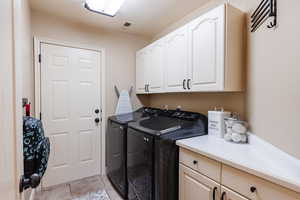 Laundry room with independent washer and dryer and cabinet space