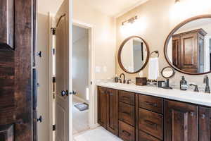 Bathroom featuring double vanity and light colored carpet