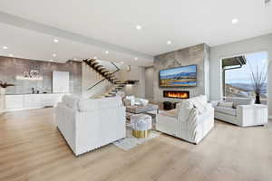Living area featuring recessed lighting, light wood-style flooring, and a tiled fireplace