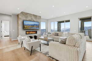 Living area featuring light wood finished floors, a fireplace, and recessed lighting