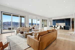 Living room with light wood finished floors, recessed lighting, and a mountain view