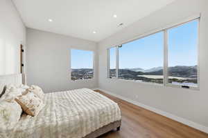 Bedroom featuring light wood finished floors, a mountain view, and recessed lighting