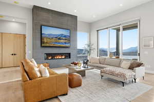 Living room featuring wood finished floors, recessed lighting, and a tile fireplace