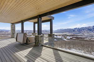 Wooden deck featuring a mountain view and a patio