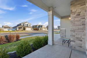 Covered porch featuring a residential view