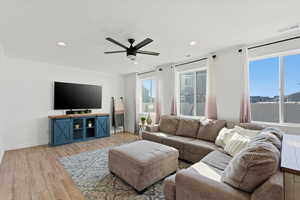 Living area with light wood finished floors, ceiling fan, and recessed lighting