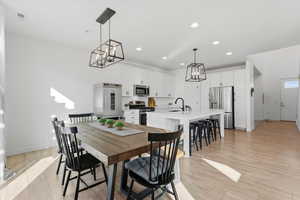 Dining area featuring a chandelier, recessed lighting, and light wood-style flooring