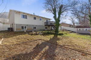 Rear view of property with a fenced backyard, a storage shed, and a deck