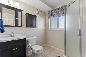 Full bath featuring a stall shower, vanity, and light tile patterned floors